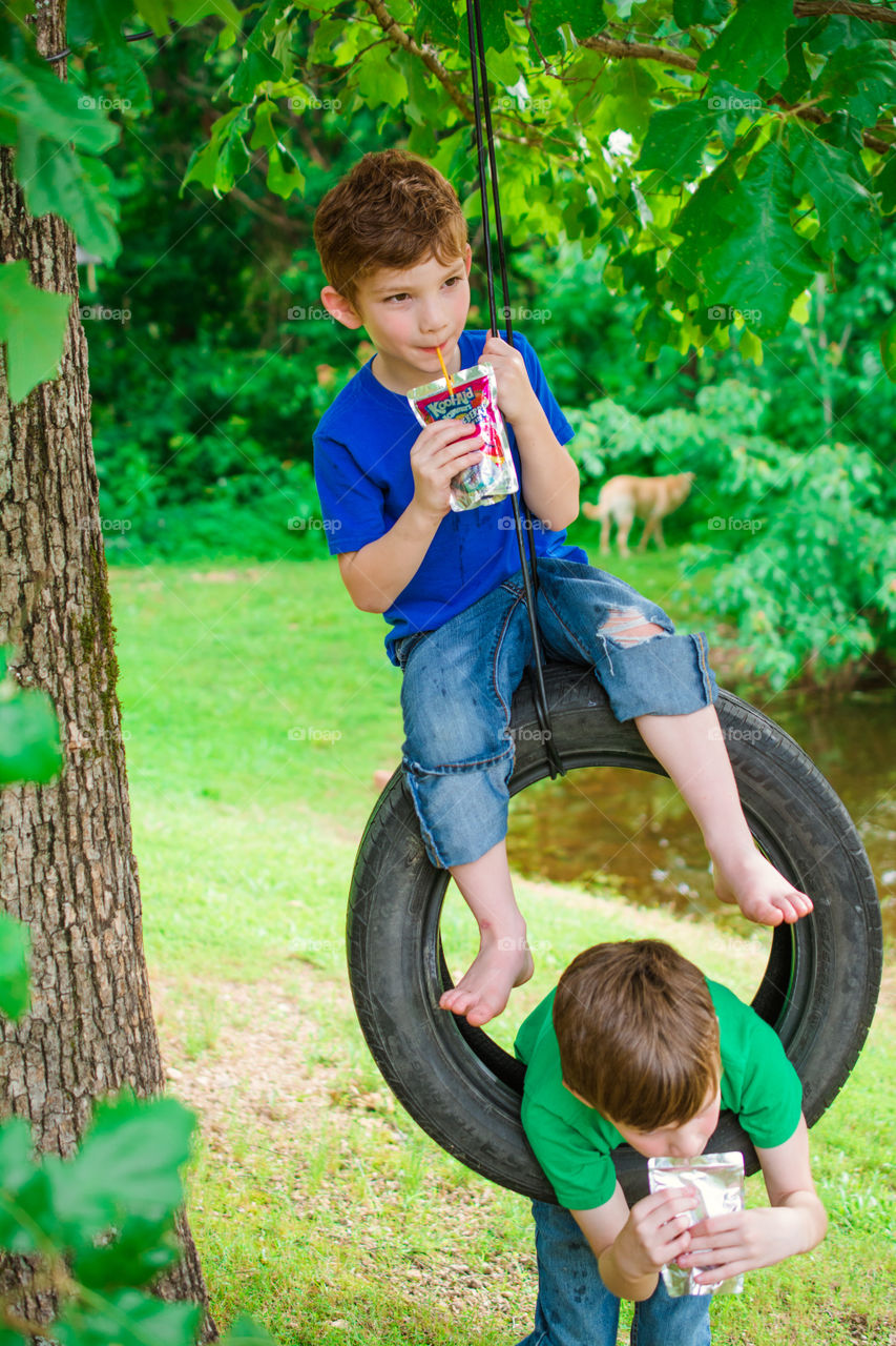 Young Boys on a Tire Swing Drinking Kool Aid Jammers