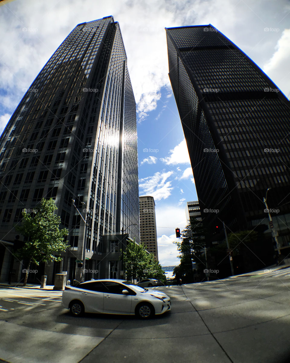 Two high rise building stand in Seattle nearby downtown. Just took a shot while a car is passing in the frame and not bad for the position.