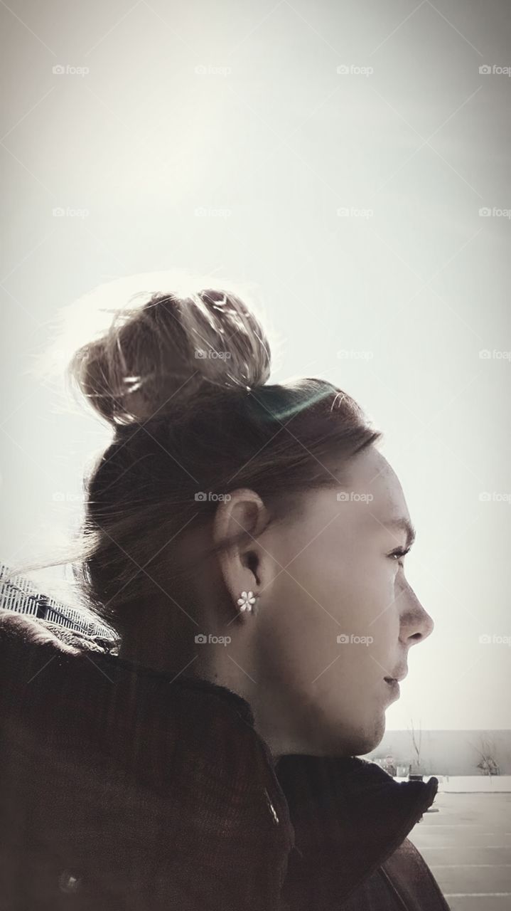 black and white side profile of woman with a bun