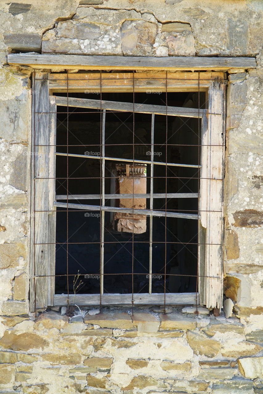 Decaying window covered with steel mesh