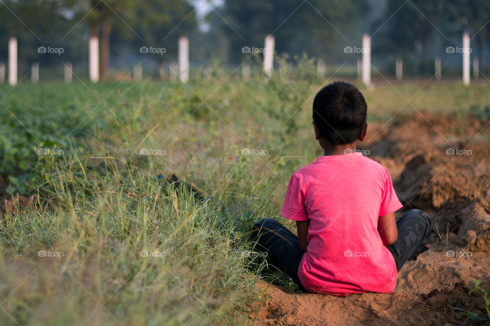 a boy sitting with sad