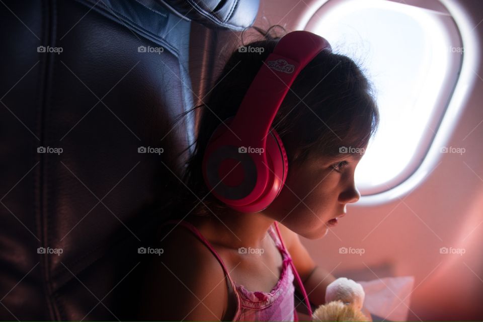 Little girl in plane . Watching a movie during the flight 