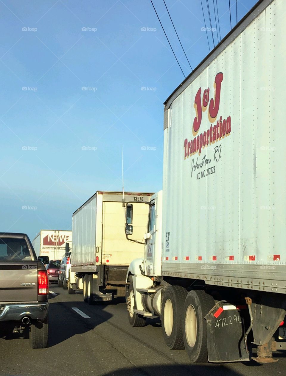 Tractor Trailer convoy. Big rigs, tractor trailers traveling down the highway in truck lane. Trucks following each other, one after the other.