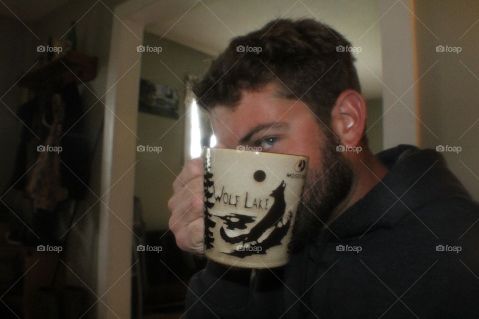 Man holding cup of coffee in a neat wolf mug