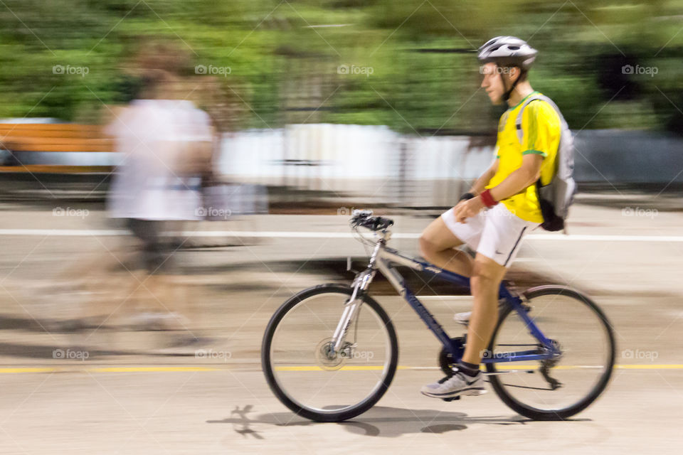 Young Man On Bike Ride In The City Wearing Bicycle Helmet
