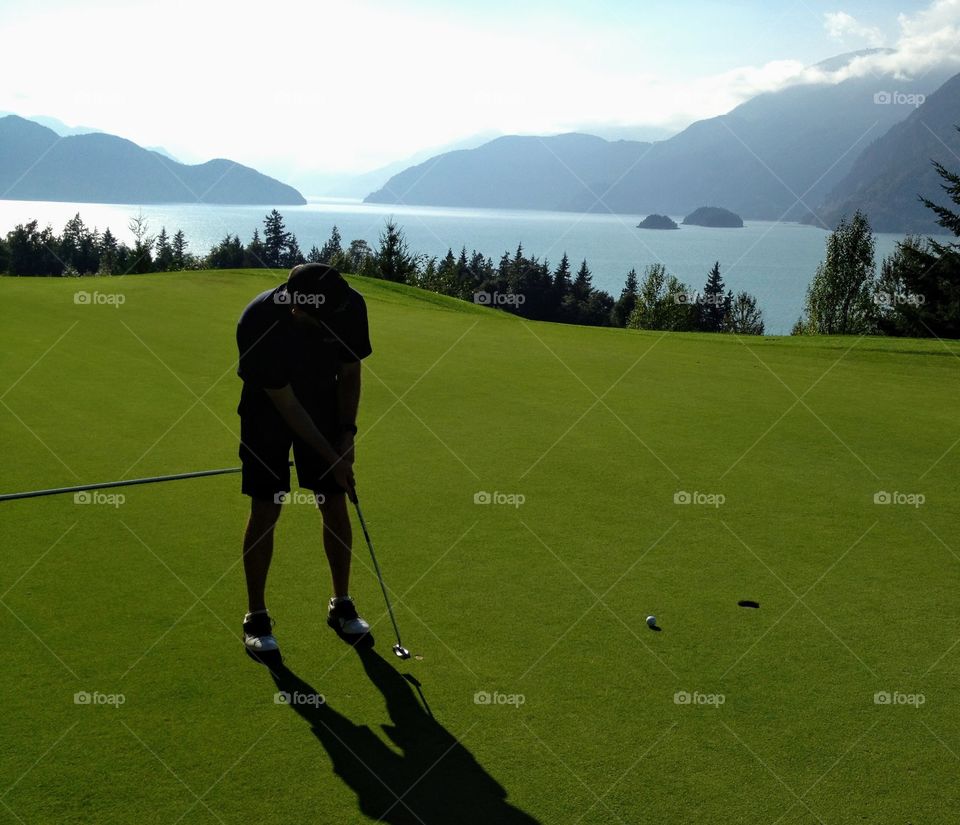 Putting for birdie along beautiful Howe Sound, BC, Canada.  Ocean glowing in the background.