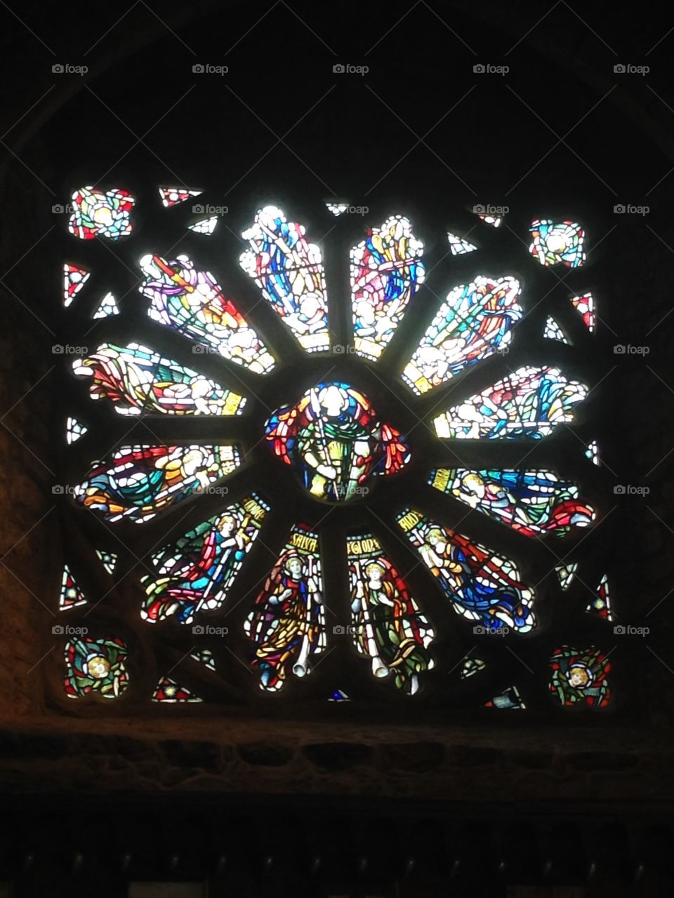 A circle of saints or angels in stain glass window of a church.