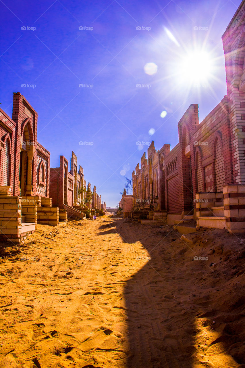 2 sides of buildings facing each other in a sunny day in a cemetery