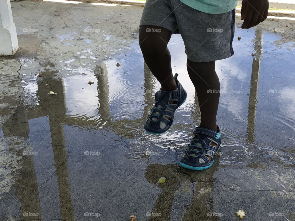 Boy jumping in puddle