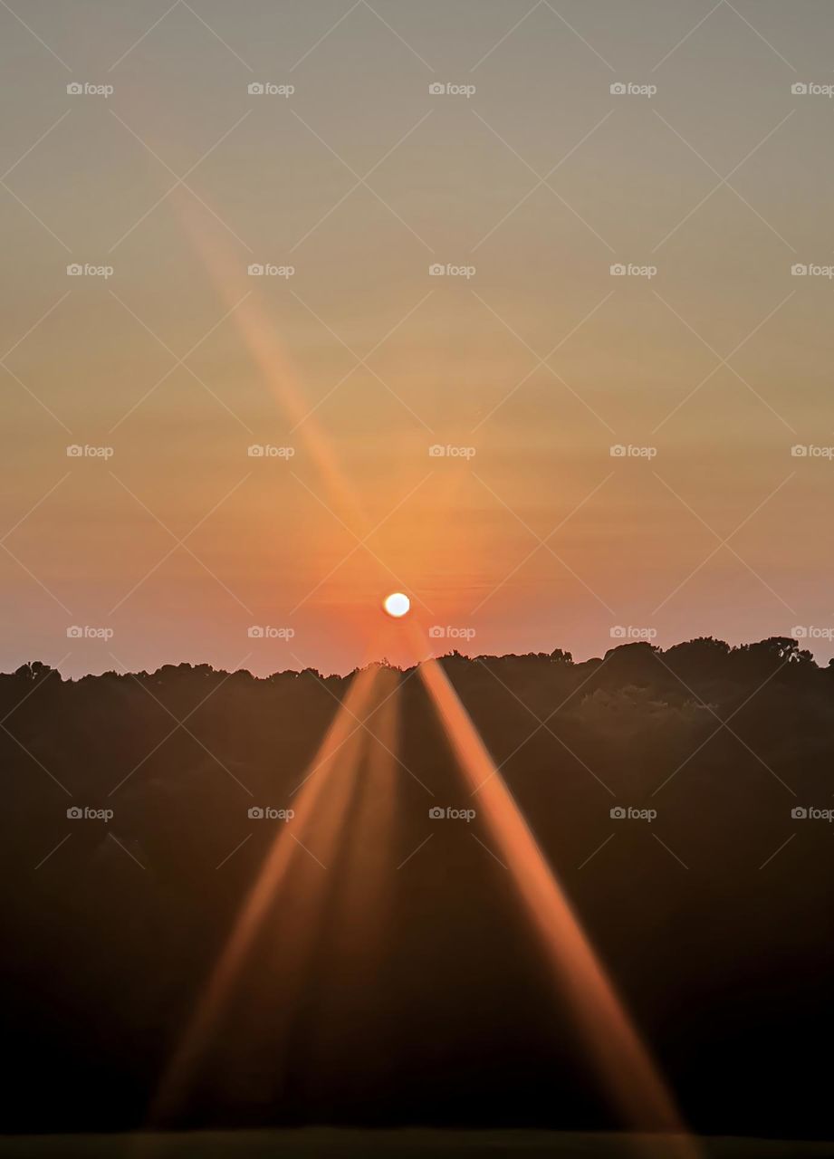 The August sunset radiating beautiful, orange , deep rays as the day comes to a close.