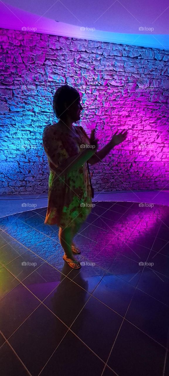lady dancing in disco lights of pink and blue clapping, silhoette shadow