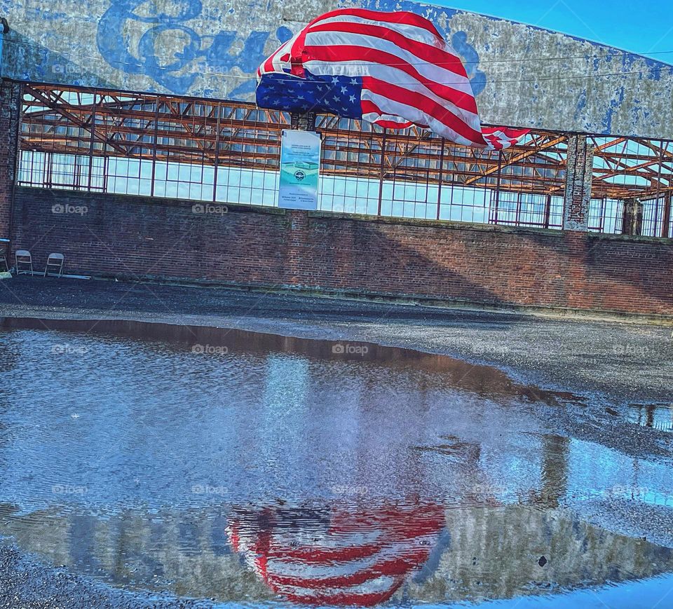 Flags reflection in a puddle after the rains 