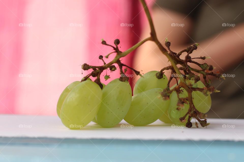 Close-up of fresh bunch of grapes on blue table
