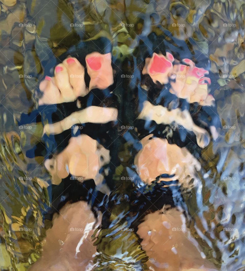 Feet in river. Cooling off during a hot outing. Summer rivers, fishing, rafting, floating are some of the favorite MT summer activities