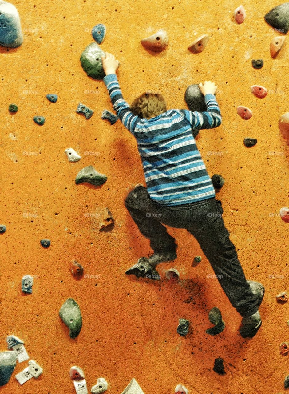 Boy Climbing A Rock Wall
