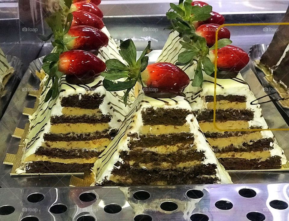 Cream and chocolate pyramid with strawberry 