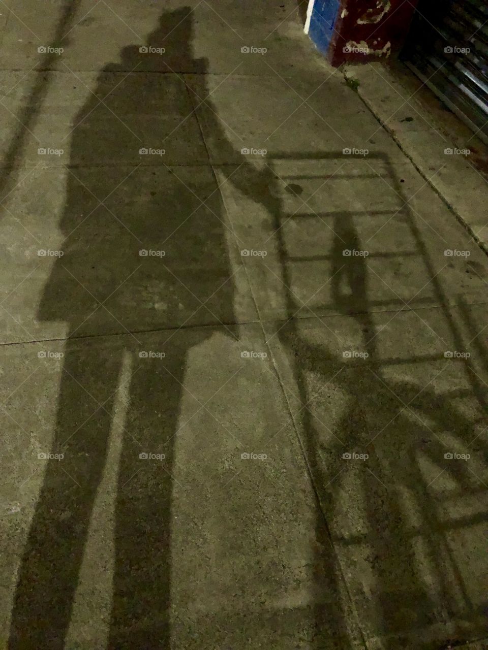 My shadow as I’m pushing a cart down the street at night 
