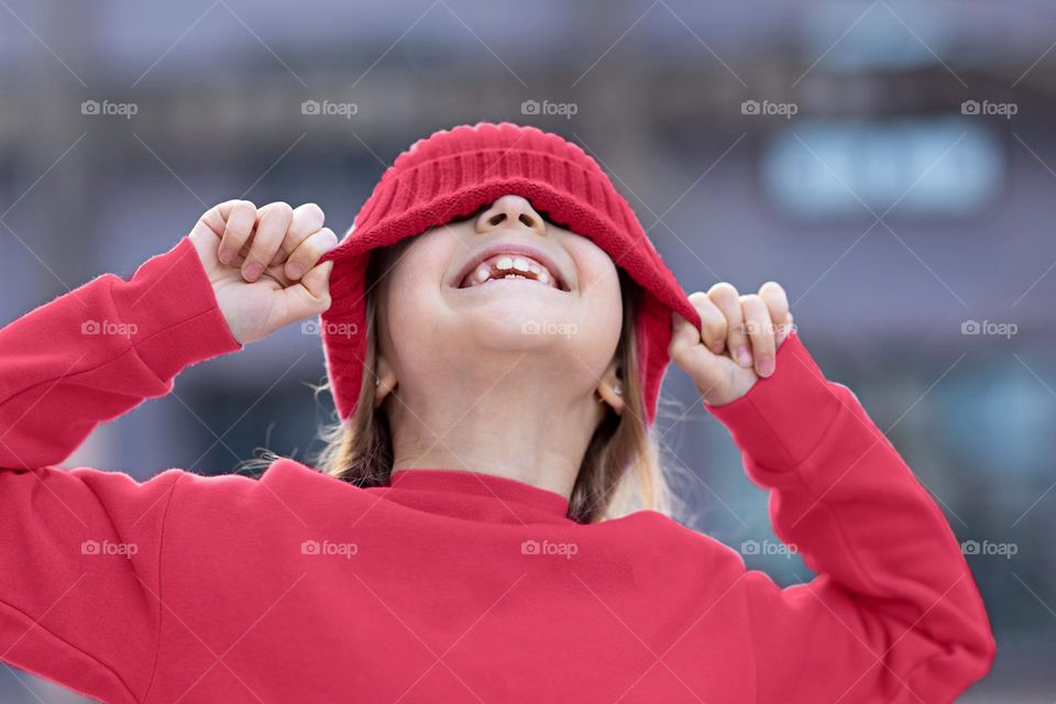 Happy little Caucasian girl wearing trendy clothing viva magenta colored 