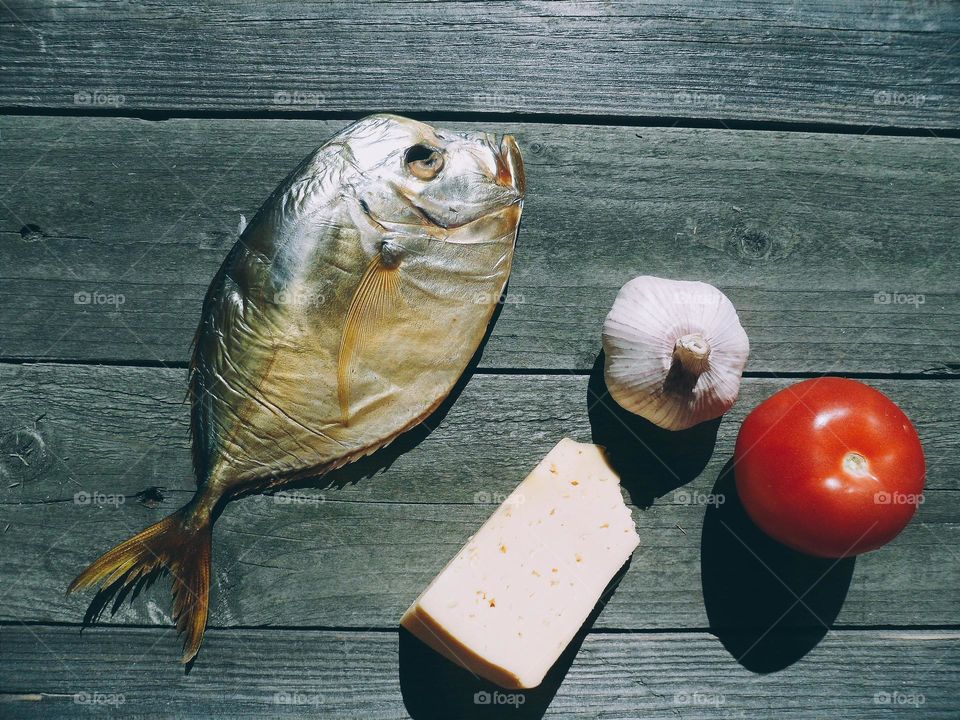 dried fish, tomato, cheese and garlic on a table