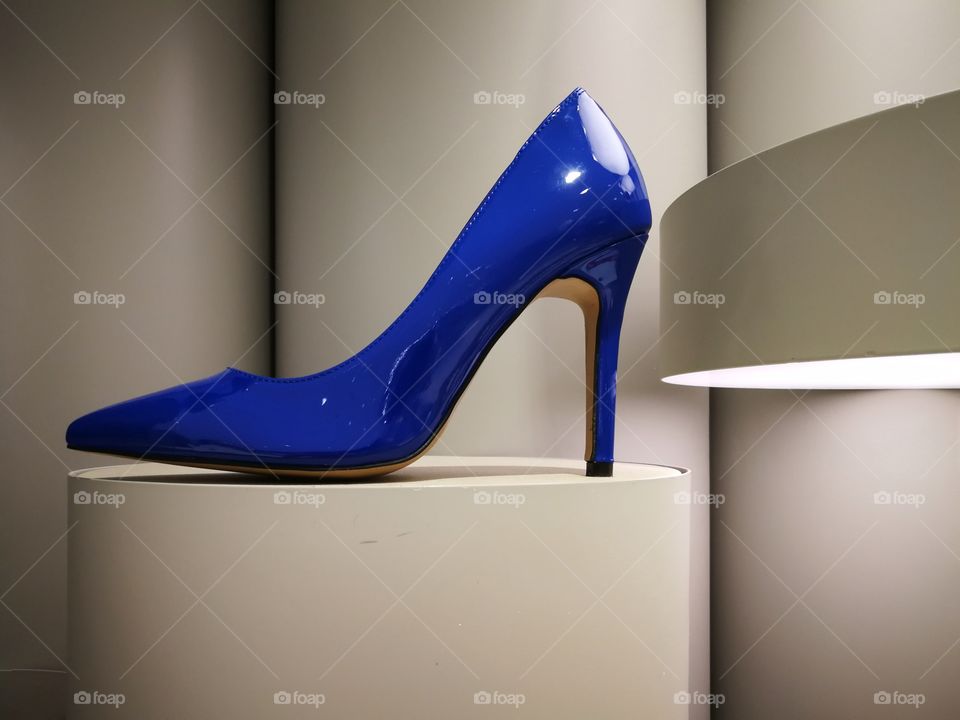 Glossy bright blue high heel on display