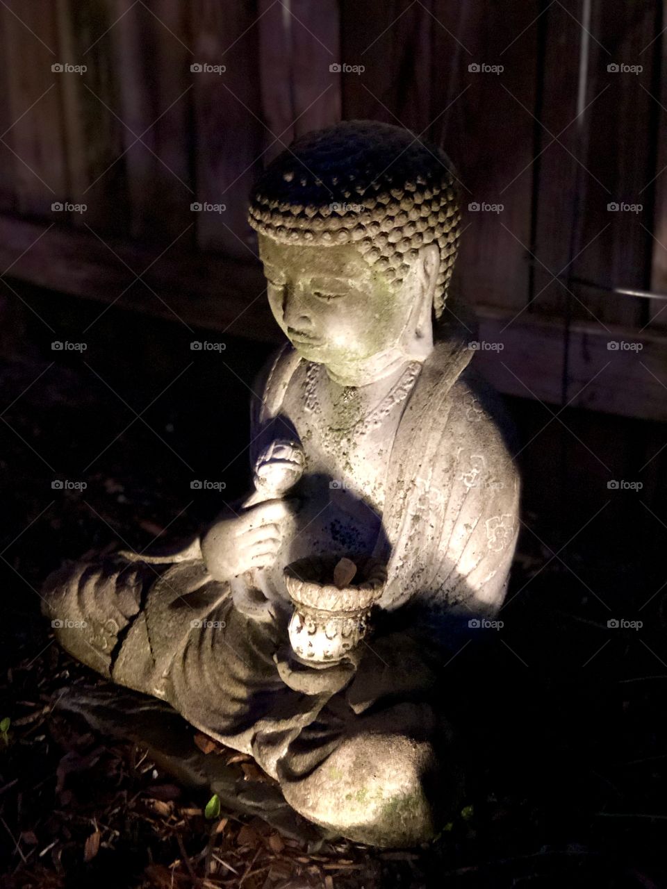 Religious statue in a garden at night