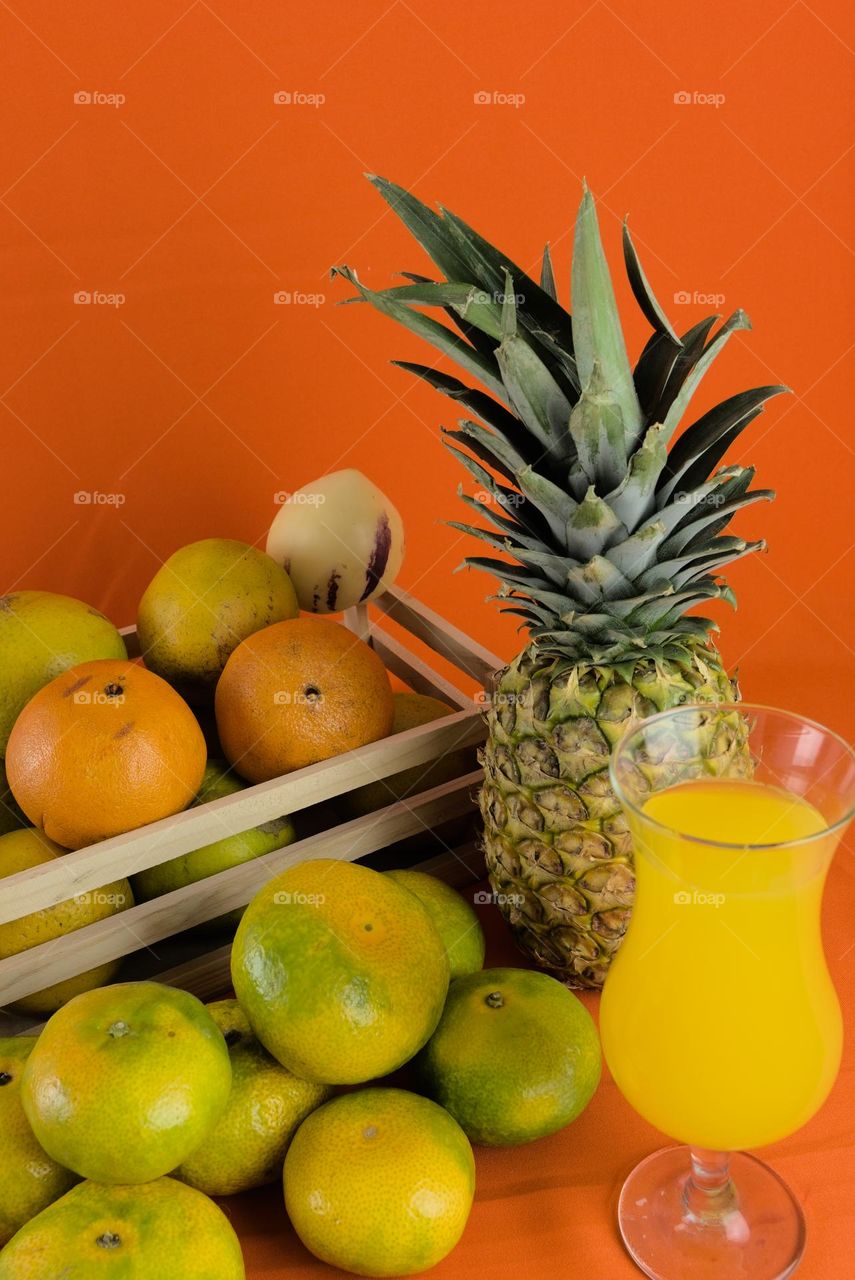 Oranges and Glass with natural juice on an orange background