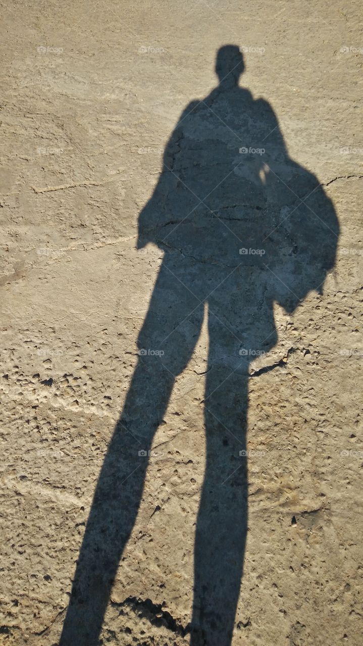 an human shadow reflected in the concrete