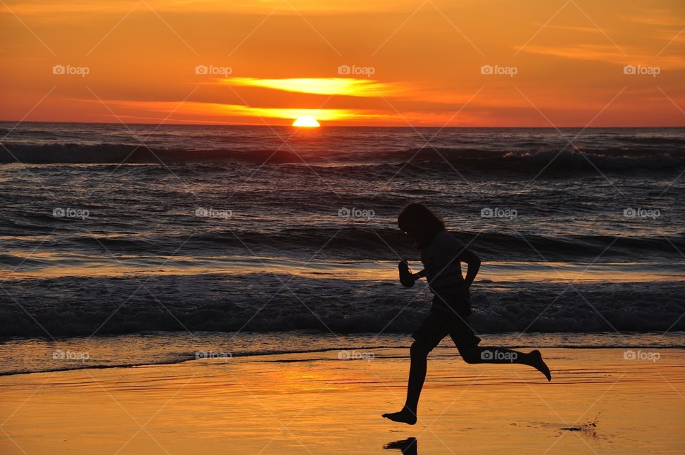 Sunset Run. Silhouette of rubber on beach at sunset 