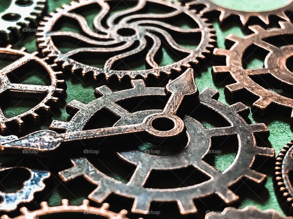 Close up of metal copper cogs on a green background 