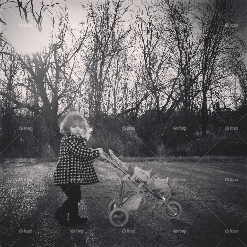 Strolling her baby doll to sleep. Black and white memories.