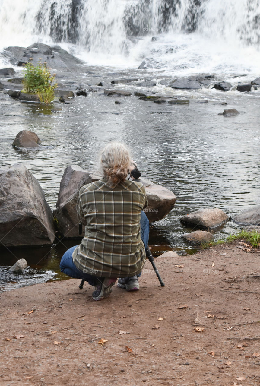 Woman photographing a waterfall