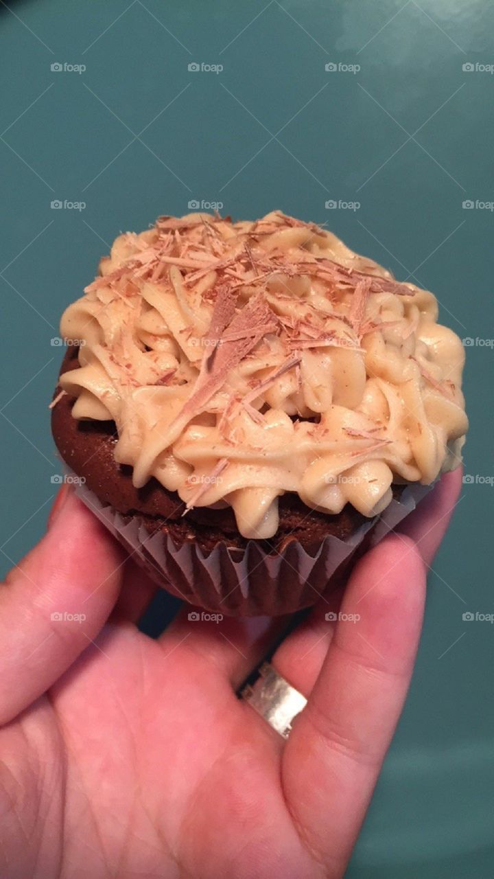 Double chocolate cupcake with peanut butter frosting and chocolate shavings on top.
