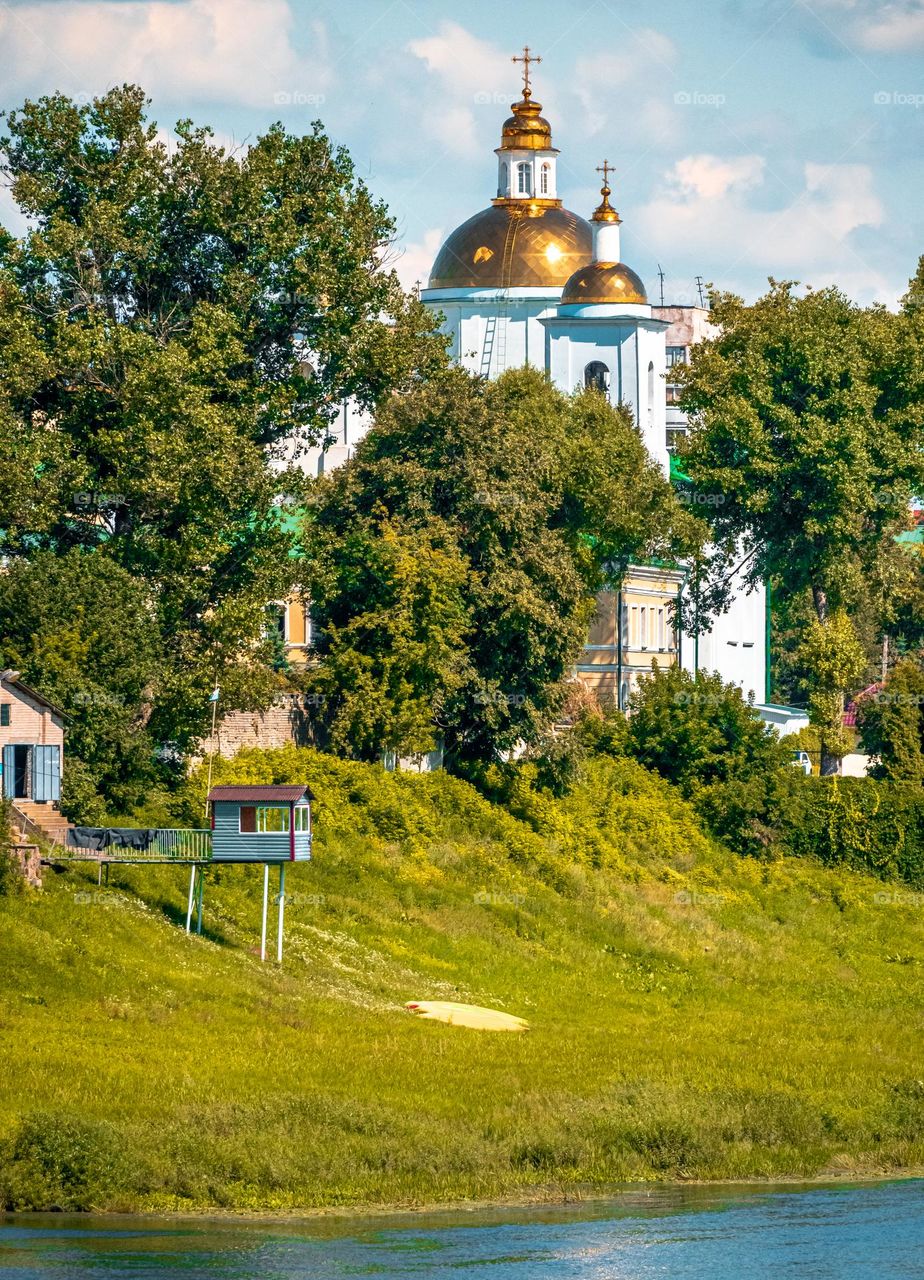 Cathedral on the river bank in the summer