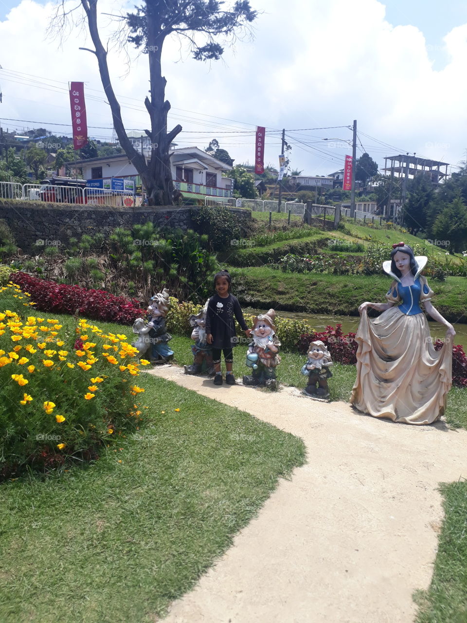 A small girl in a beautiful garden,have snow white and the seven dwarfvers Too