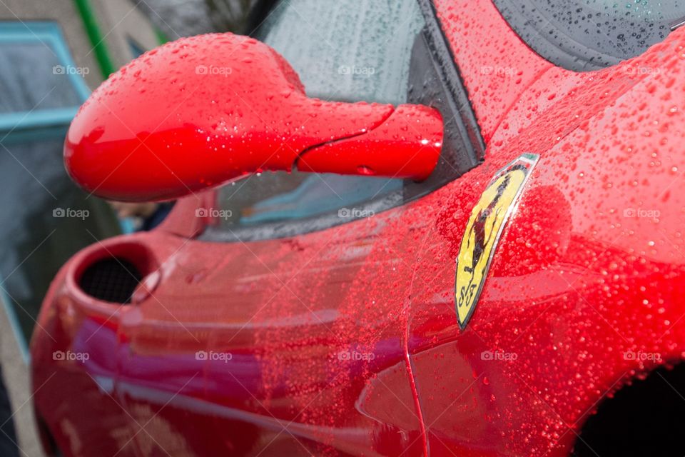 Blood red Ferrari coverd in rain drops 