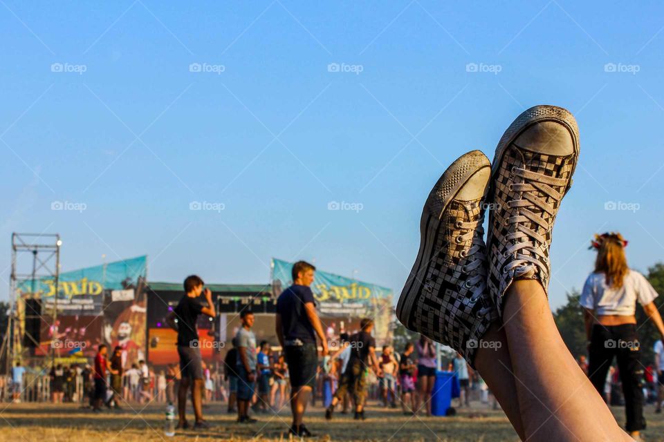 Legs in sneakers is on the summer festival.