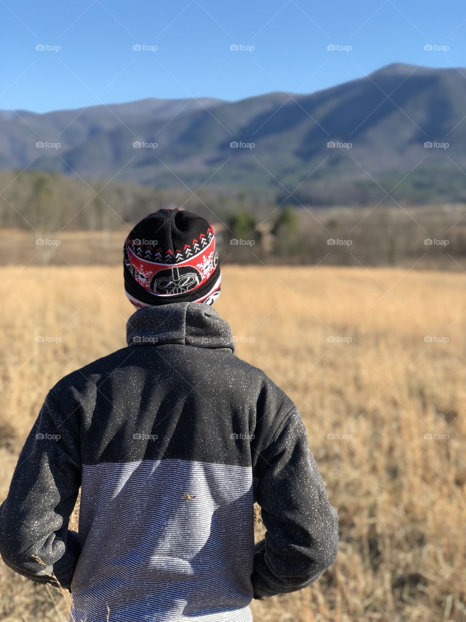 Single boy hiking in the mountains in the fall