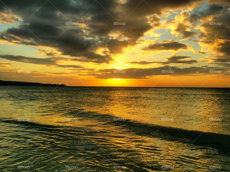 Sea against dramatic sky during sunset