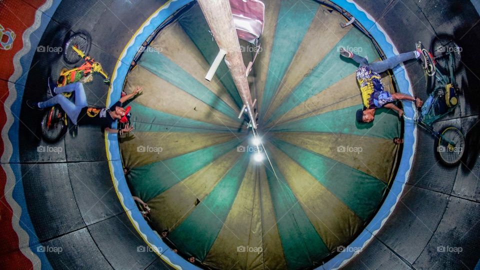 a flywheel show featuring two motorbikes riding around in a giant barrel