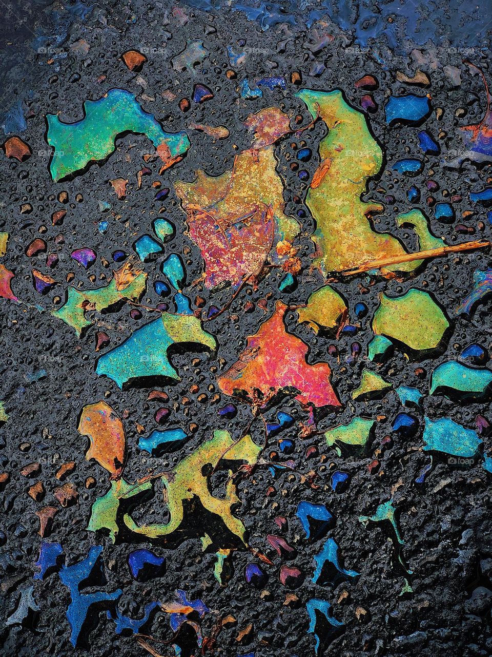 Spring colors in the parking lot, colorful oil spilled, water and oil do not mix, colors of the spring, driving in the springtime 