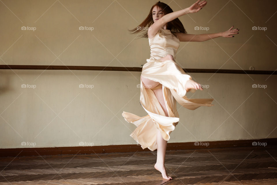 Beautiful young woman dancing in studio