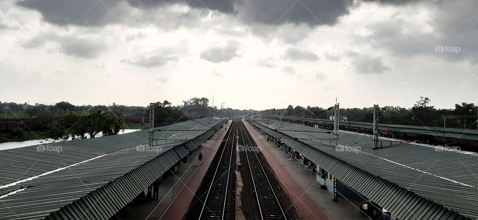 View from the footbridge showing the overall railway track ,platform canopies.Photo clicked in a cloudy weather.