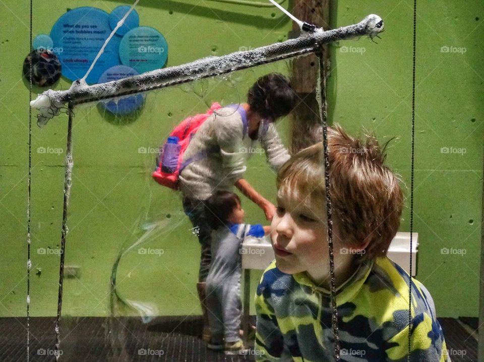 Blowing A Giant Bubble. Boy Experiments With Fluid Dynamics
