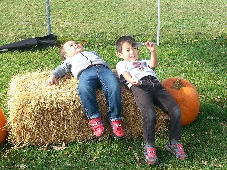 fun fall day. boys on bale of hay