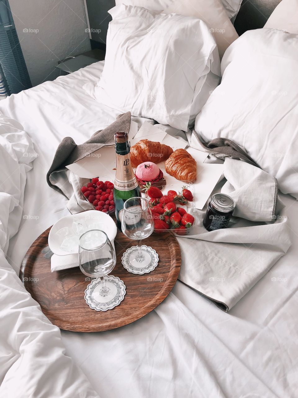 Romantic picnic in bed. Champagne, croissants and strawberry. French style. Eating and bed. Romantic morning. 