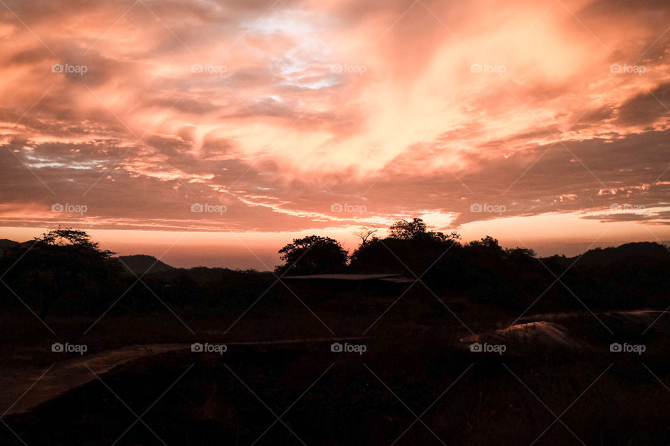 cielo rojo con el sol ocultado tras nubes