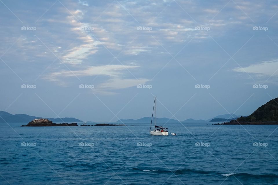 Sailboat cruising through the beautiful blue hues of the Whitsunday Islands, Australia 