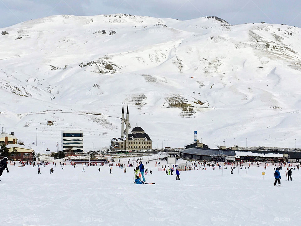 Snowy ski slope in the ski resort with a mosque in the background