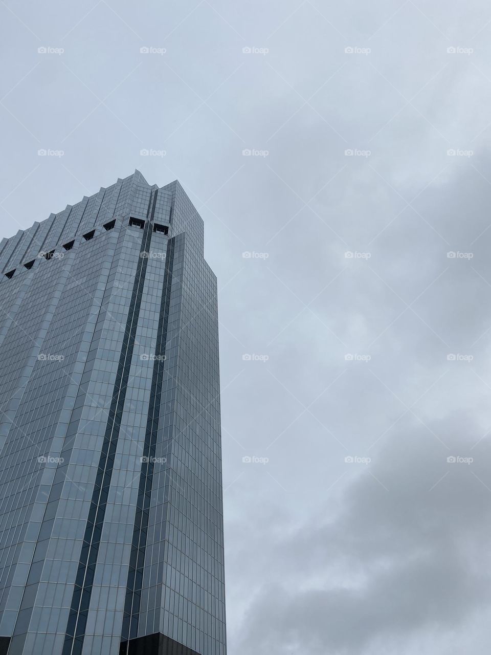 Skyscraper against cloudy sky