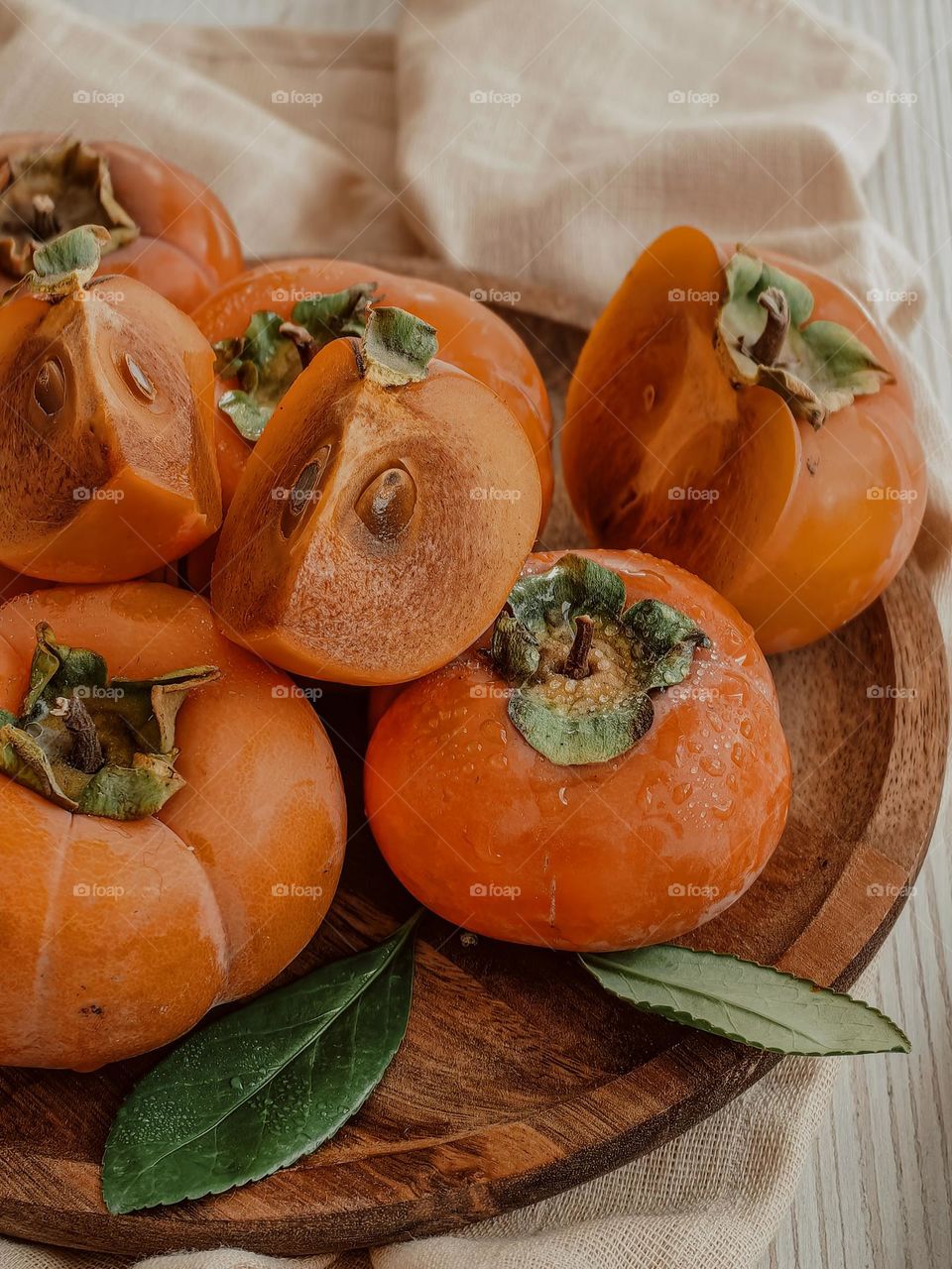 Persimmon on a wooden plate